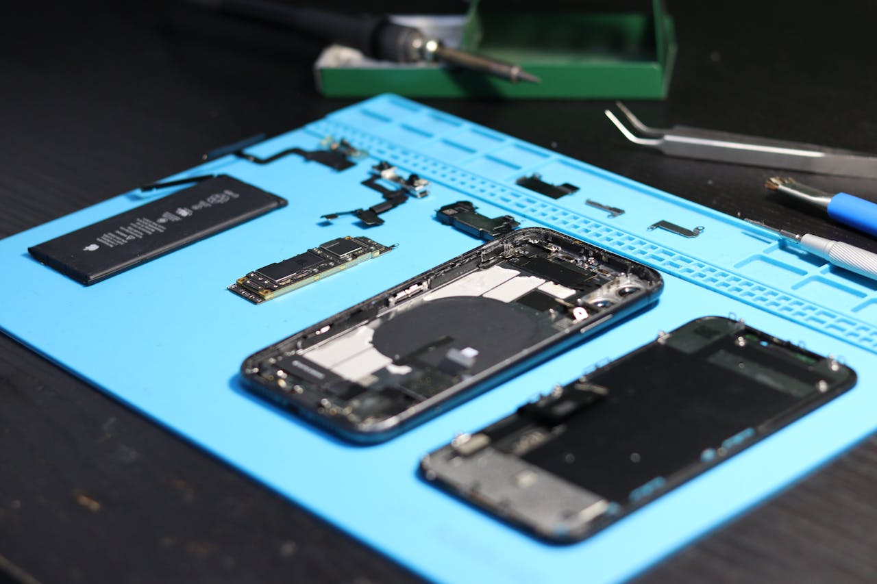Inicio Disassembled smartphone with tools on a workbench, emphasizing repair and technology.